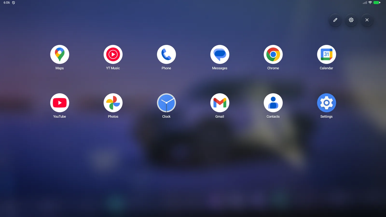 The favourites launcher floating over the blurred car home screen: twelve app icons in two rows, including Maps, YT Music, Phone and Chrome, with edit, settings and close buttons.